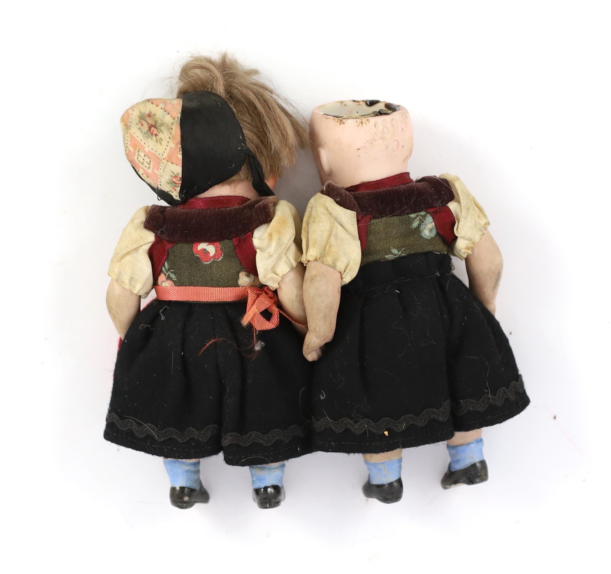 A pair of German all-bisque dolls with 'googly’ eyes, 14cm